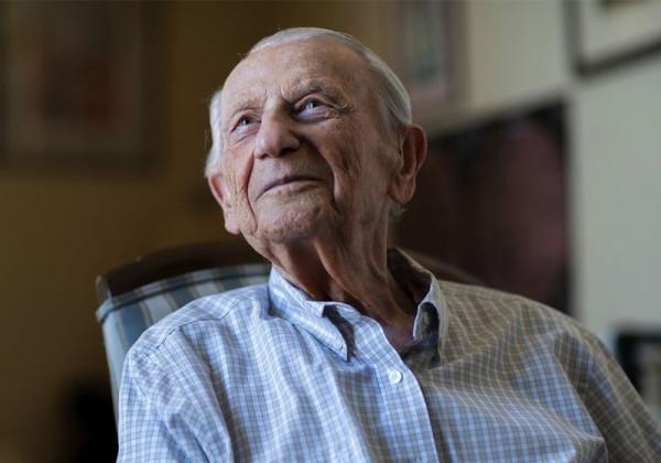 Alumnus Sigmund Burke sitting in chair looking into the distance.